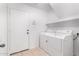 Laundry room with washer, dryer, overhead shelf, and tile flooring at 12905 W Soledad St, El Mirage, AZ 85335