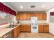 Kitchen features oak cabinets, white appliances, and tile floor at 2083 S 155Th Ln, Goodyear, AZ 85338