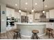 Modern kitchen with white cabinets, stainless steel appliances, a large island, and stylish pendant lighting at 27421 W Pontiac Dr, Buckeye, AZ 85396