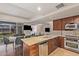 Open kitchen with stainless steel appliances, granite countertops, wood cabinetry, and dining area at 7151 E Rancho Vista Dr # 4001, Scottsdale, AZ 85251
