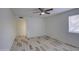 Bedroom with wood-look tile floors, ceiling fan, and a door to another room at 7431 W Ocotillo Rd, Glendale, AZ 85303