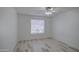 Bright bedroom with wood-look tile flooring, ceiling fan, and window with blinds at 7431 W Ocotillo Rd, Glendale, AZ 85303