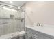 Modern bathroom featuring a walk-in shower, white vanity, and gray tile at 7502 W Cora Ln, Phoenix, AZ 85033