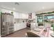 Modern kitchen with white cabinets, stainless steel appliances, and an adjacent dining area at 7502 W Cora Ln, Phoenix, AZ 85033