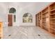 Spacious living area with tiled flooring, a built-in bookcase, and an arched window at 808 N Williams Cir, Mesa, AZ 85203