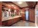 Modern bathroom with double sinks, wooden cabinetry, and tiled floor at 8702 E Silver Saddle Dr, Carefree, AZ 85377