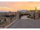 Gated driveway at sunset leading to a luxurious desert home at 8702 E Silver Saddle Dr, Carefree, AZ 85377