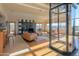 Open living room with a fireplace, glass elevator, and large windows showing mountain views at 8702 E Silver Saddle Dr, Carefree, AZ 85377