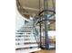 Elegant curved staircase next to a glass elevator at 8702 E Silver Saddle Dr, Carefree, AZ 85377