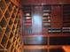Custom wine cellar with wooden shelves for storing wine bottles and other beverages at 8702 E Silver Saddle Dr, Carefree, AZ 85377