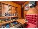 Wine cellar with storage shelves, a table, and a red leather booth at 8702 E Silver Saddle Dr, Carefree, AZ 85377