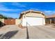 Tan house with white garage door and wooden gate at 13992 W Maui Ln, Surprise, AZ 85379