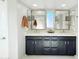 Modern bathroom with dark navy vanity, double sinks, and gold fixtures at 1735 S Balboa Dr, Gilbert, AZ 85295