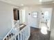 Upstairs hallway with carpeted flooring, white railings, and access to laundry at 1735 S Balboa Dr, Gilbert, AZ 85295