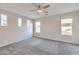 Bright bedroom with carpeted floors and multiple windows at 43202 W Delia Blvd, Maricopa, AZ 85138