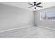 Empty bedroom featuring wood-look flooring, a ceiling fan, and window with blinds at 5620 N 71St Ave, Glendale, AZ 85303