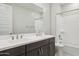 Double vanity bathroom with dark brown cabinets and a bathtub at 5807 E Rose Garden Ln, Phoenix, AZ 85054