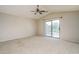 Spacious bedroom with carpeted flooring, ceiling fan, and sliding glass door to balcony at 5852 S 248Th Ln, Buckeye, AZ 85326