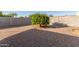 Backyard with a mature citrus tree, gravel ground cover, and a partially shaded area at 6424 E Dallas St, Mesa, AZ 85205