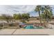 View from balcony of backyard with in-ground pool, green space, patio furniture, and palm trees at 912 N 164Th Dr, Goodyear, AZ 85338