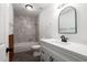 Bathroom with marble tile shower, white vanity, and wood-look flooring at 1430 W Maddock Rd, Phoenix, AZ 85086