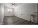 Empty bedroom with gray wood-look flooring, white walls, and a ceiling fan at 1430 W Maddock Rd, Phoenix, AZ 85086