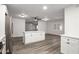 White kitchen with island, stainless steel appliances, and wood-look flooring at 1430 W Maddock Rd, Phoenix, AZ 85086