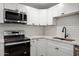 Updated kitchen featuring white shaker cabinets, stainless steel appliances, and quartz countertops at 1430 W Maddock Rd, Phoenix, AZ 85086