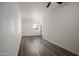 Empty living room with wood-look floors, white walls, and a door to the exterior at 1430 W Maddock Rd, Phoenix, AZ 85086