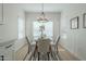 Bright dining area with a modern chandelier, glass-top table, and upholstered chairs at 15720 W Goldenrod Dr, Surprise, AZ 85374