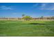 Lush green golf course with homes in the background at 15720 W Goldenrod Dr, Surprise, AZ 85374