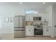 Well-appointed kitchen with white cabinetry, stainless steel appliances, and a view of the dining area at 15720 W Goldenrod Dr, Surprise, AZ 85374