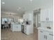 Spacious kitchen with white cabinets, stainless steel sink, and a view of the dining area at 15720 W Goldenrod Dr, Surprise, AZ 85374