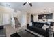 Open living area with dark-colored sofas, a glass coffee table, and stairs leading upstairs at 2339 E University Dr # 17, Mesa, AZ 85213