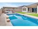 Relaxing backyard oasis featuring a pool, covered patio, and built-in grill at 4711 N 212Th Dr, Buckeye, AZ 85396
