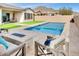Inviting backyard oasis featuring a sparkling pool, fire pit, and comfortable seating area at 4711 N 212Th Dr, Buckeye, AZ 85396