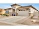 Front exterior showcasing a stone facade, attached garage, and paver driveway at 4711 N 212Th Dr, Buckeye, AZ 85396