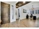 Foyer with an adjacent home office featuring a desk, chair, and shuttered window at 4711 N 212Th Dr, Buckeye, AZ 85396