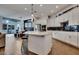 Bright, open kitchen featuring white cabinetry, island with bar seating, stainless steel appliances, and adjacent dining area at 4711 N 212Th Dr, Buckeye, AZ 85396
