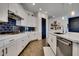 White kitchen with black tile backsplash, stainless steel appliances and large island at 4711 N 212Th Dr, Buckeye, AZ 85396