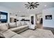 Open concept living room with sectional sofa, ceiling fan, and view of the kitchen at 4711 N 212Th Dr, Buckeye, AZ 85396