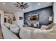 Spacious living room with an accent wall, ceiling fan, and large TV at 4711 N 212Th Dr, Buckeye, AZ 85396