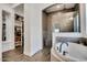 Spacious main bathroom featuring a walk-in shower, soaking tub, and wood-look tile at 4711 N 212Th Dr, Buckeye, AZ 85396