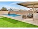 Sparkling pool with a large paved patio and green lawn at 4711 N 212Th Dr, Buckeye, AZ 85396