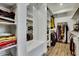 Large walk-in closet with built-in shelves, hanging rods, and a sitting area at 4711 N 212Th Dr, Buckeye, AZ 85396