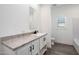 Clean and modern bathroom with white vanity, marble countertop, and wood-look flooring at 51937 W Wildwood Rd, Maricopa, AZ 85139