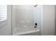 Modern bathroom with white tiled shower, bathtub, and black fixtures at 51937 W Wildwood Rd, Maricopa, AZ 85139