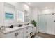 Elegant bathroom featuring a double vanity, a walk-in shower, and modern decor at 51937 W Wildwood Rd, Maricopa, AZ 85139