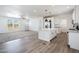 Modern kitchen with white cabinets, an island, and wood-look flooring at 51937 W Wildwood Rd, Maricopa, AZ 85139
