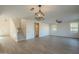 Open-concept living room with wood-look flooring, ceiling fan, and staircase at 6638 W Hughes Dr, Phoenix, AZ 85043